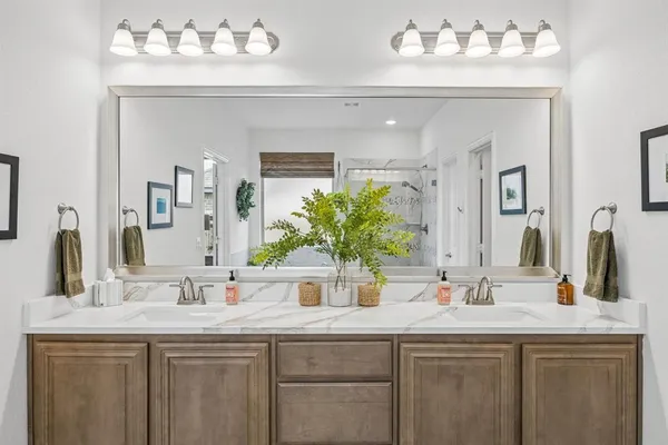 a bathroom with double vanity sinks a vanity and a mirror