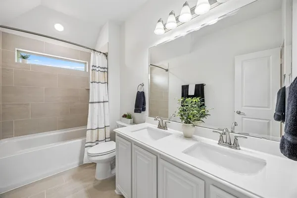 a bathroom with a granite countertop sink a toilet a mirror a bathtub and shower