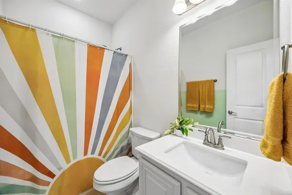 a bathroom with a sink a toilet and a mirror