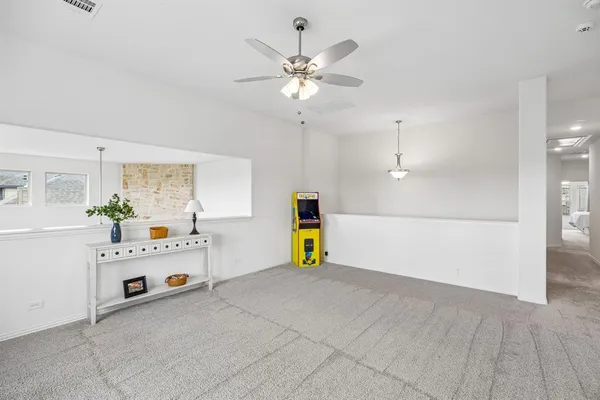 a view of an empty room with a window and a kitchen