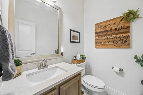 a bathroom with a sink a toilet and a mirror