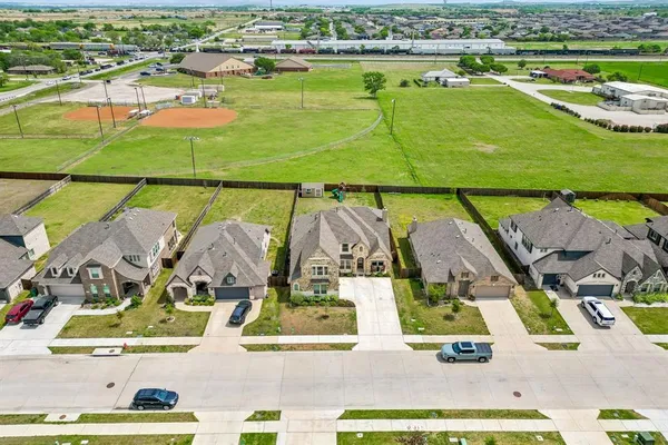an aerial view of residential houses with outdoor space and lake view