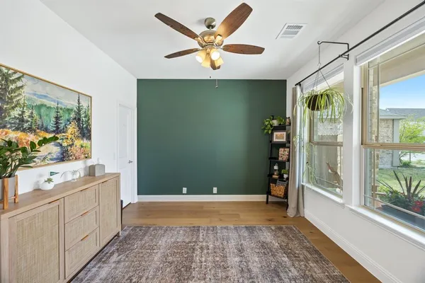 a view of an empty room with a window and cabinet