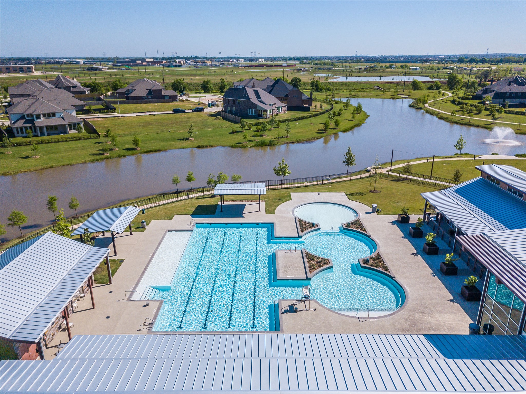 3438 Rich Radish Road Richmond, TX 77406 - Photo 23 of 25 The resort-style pool complex in Harvest Green offers dedicated spaces for both relaxation and recreation, all set against scenic waterfront surroundings. Covered gathering areas and thoughtfully designed outdoor amenities create an inviting environment for residents to enjoy year-round community living.