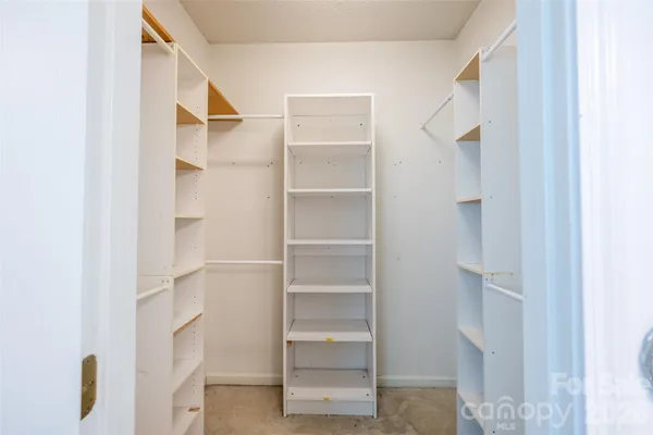 a view of walk in closet with empty racks