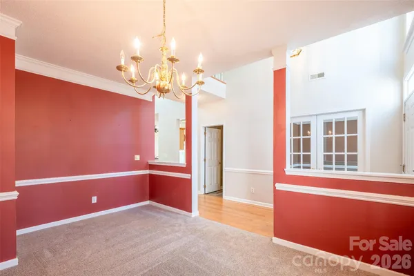 a view of a livingroom with a chandelier fan and windows