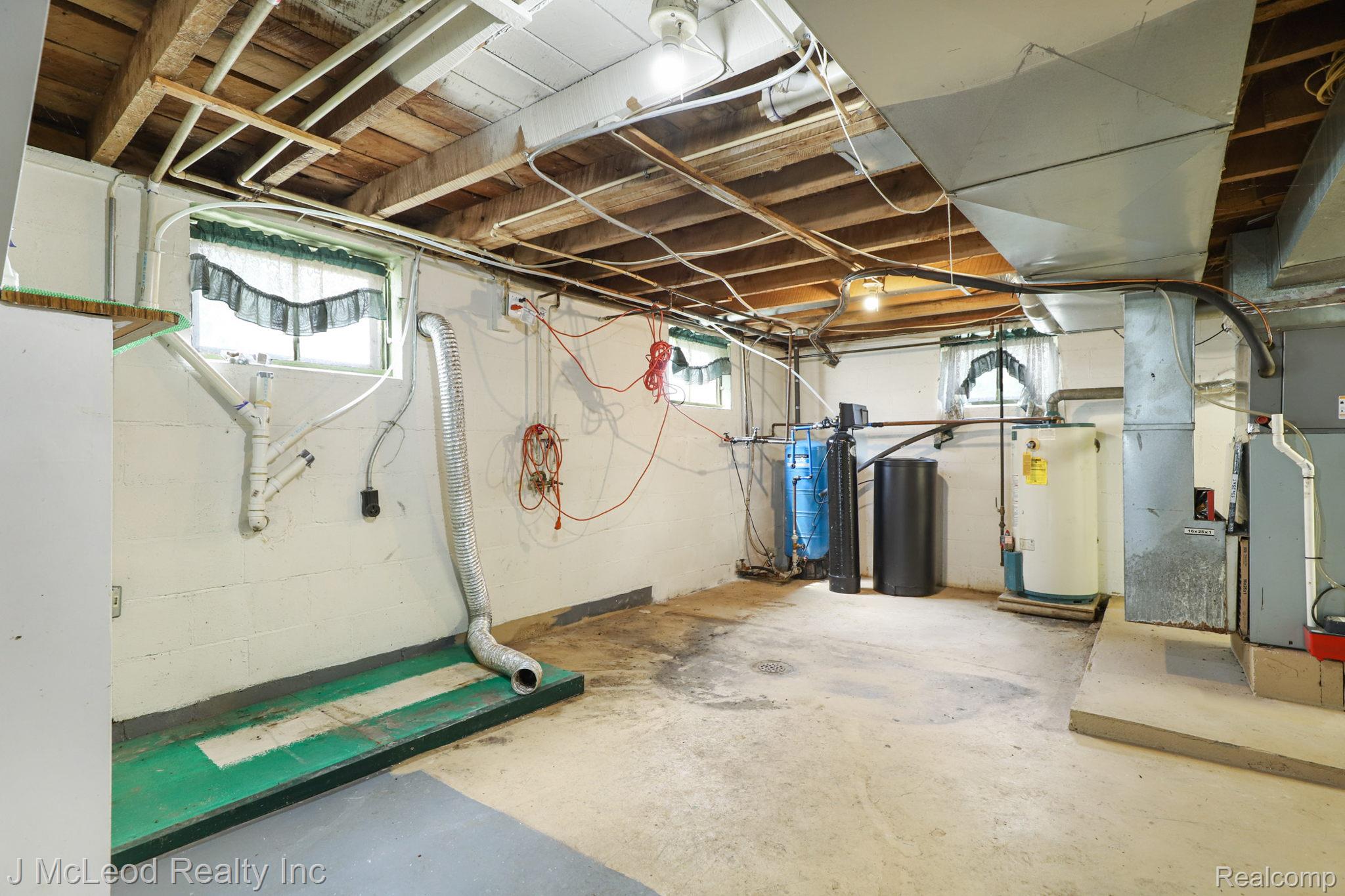 69 West Snover Road Mayville, MI 48744 - Photo 24 of 46 Concrete flooring, exposed ceiling joists, and a water heater