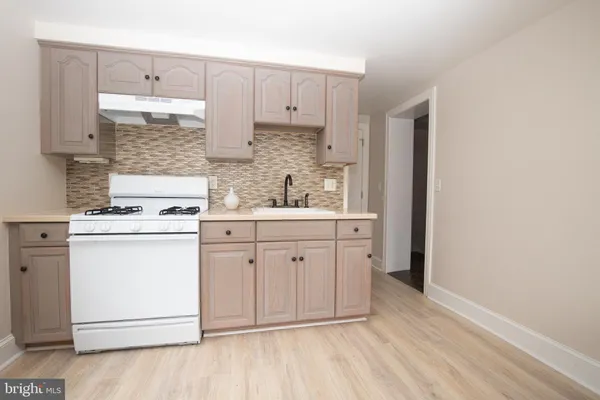 a kitchen with white cabinets and white appliances