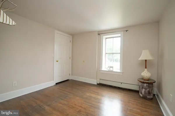 an empty room with wooden floor and window