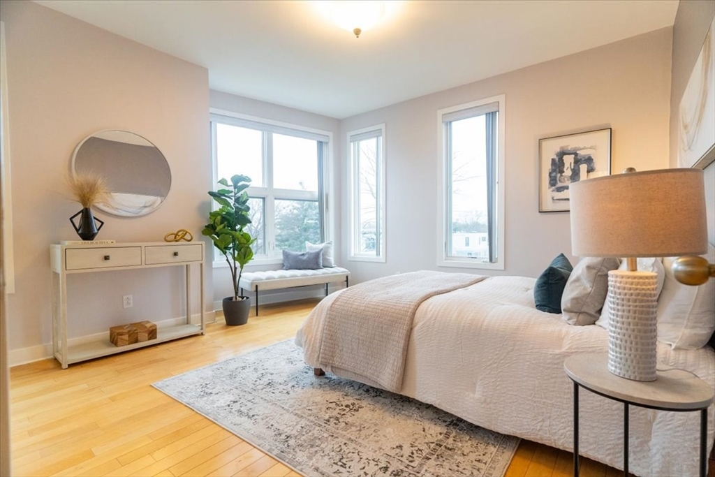 24 Bay State Road, Unit 18 Cambridge, MA 02138 - Photo 15 of 27 a bedroom with a bed a couch and large window