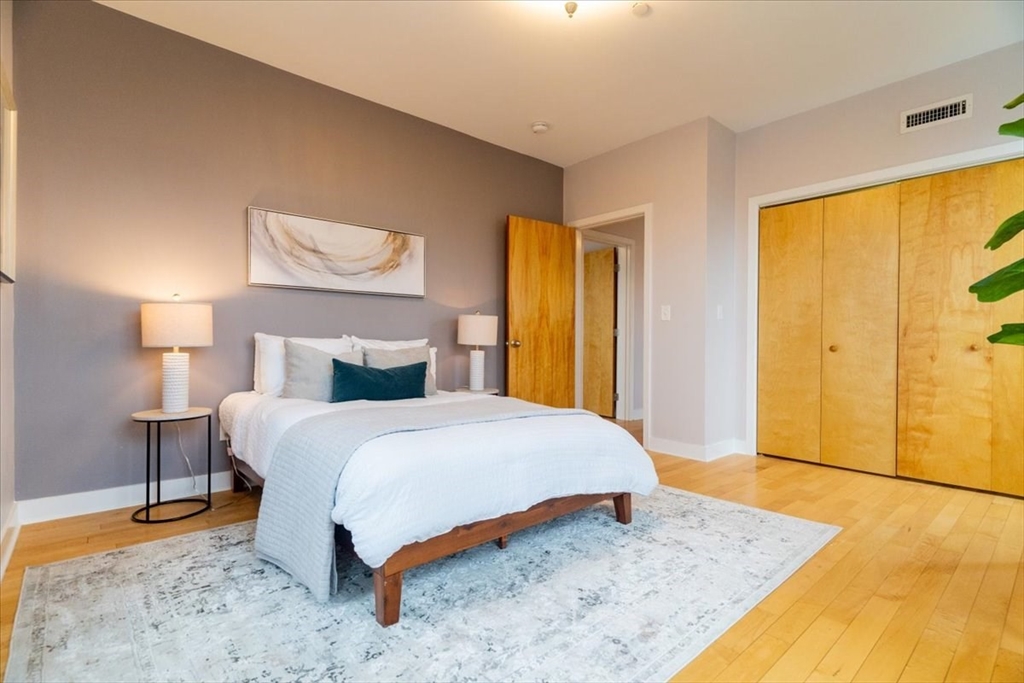 24 Bay State Road, Unit 18 Cambridge, MA 02138 - Photo 17 of 27 a bedroom with a bed and wooden floor