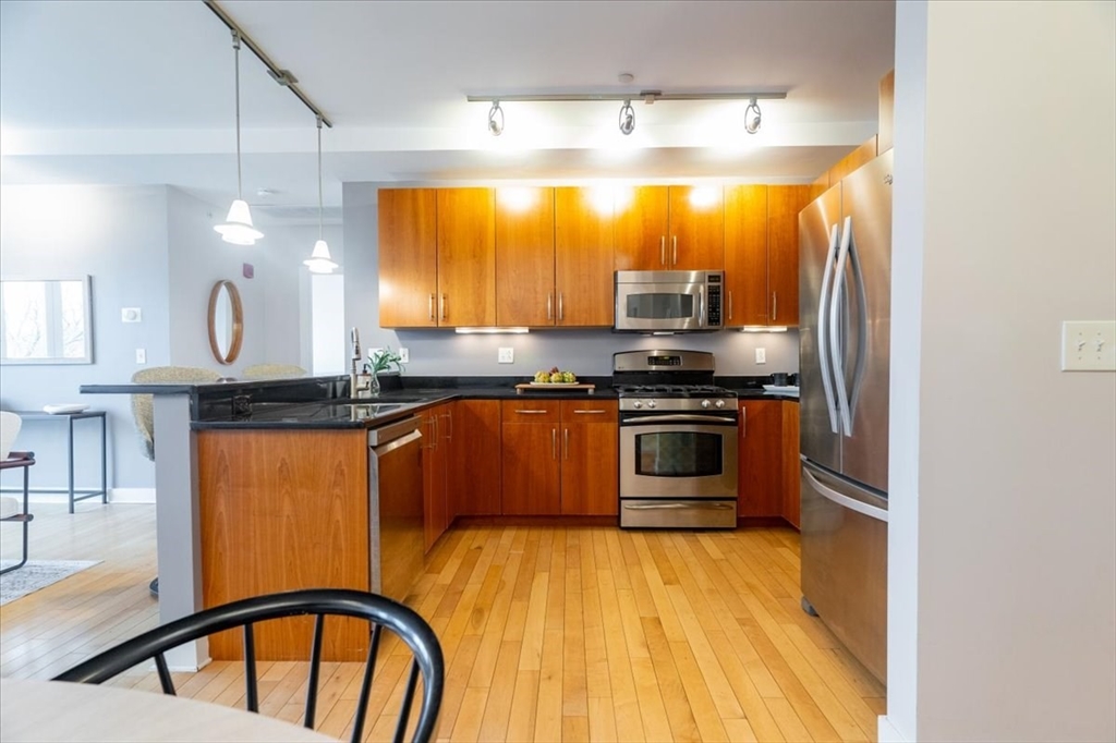 24 Bay State Road, Unit 18 Cambridge, MA 02138 - Photo 9 of 27 a kitchen with stainless steel appliances granite countertop a stove a sink and a refrigerator