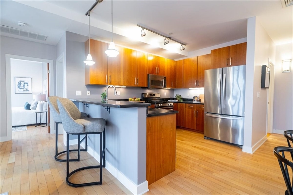 24 Bay State Road, Unit 18 Cambridge, MA 02138 - Photo 10 of 27 a kitchen with stainless steel appliances a refrigerator a stove a sink dishwasher and a microwave