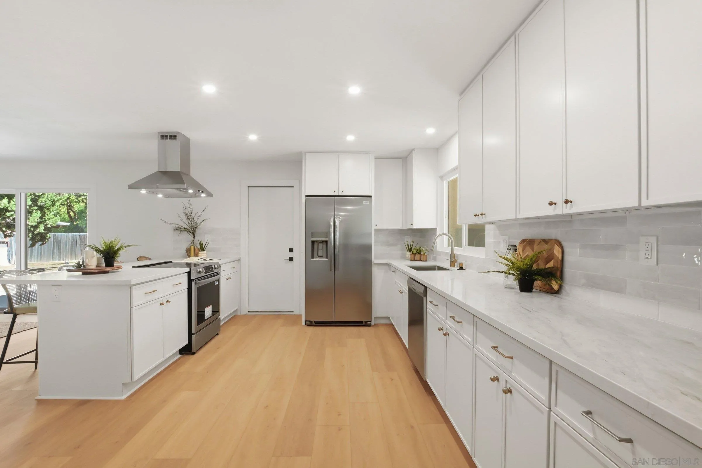 646 Barsby Street Vista, CA 92084 - Photo 12 of 48 a kitchen with white cabinets and stainless steel appliances