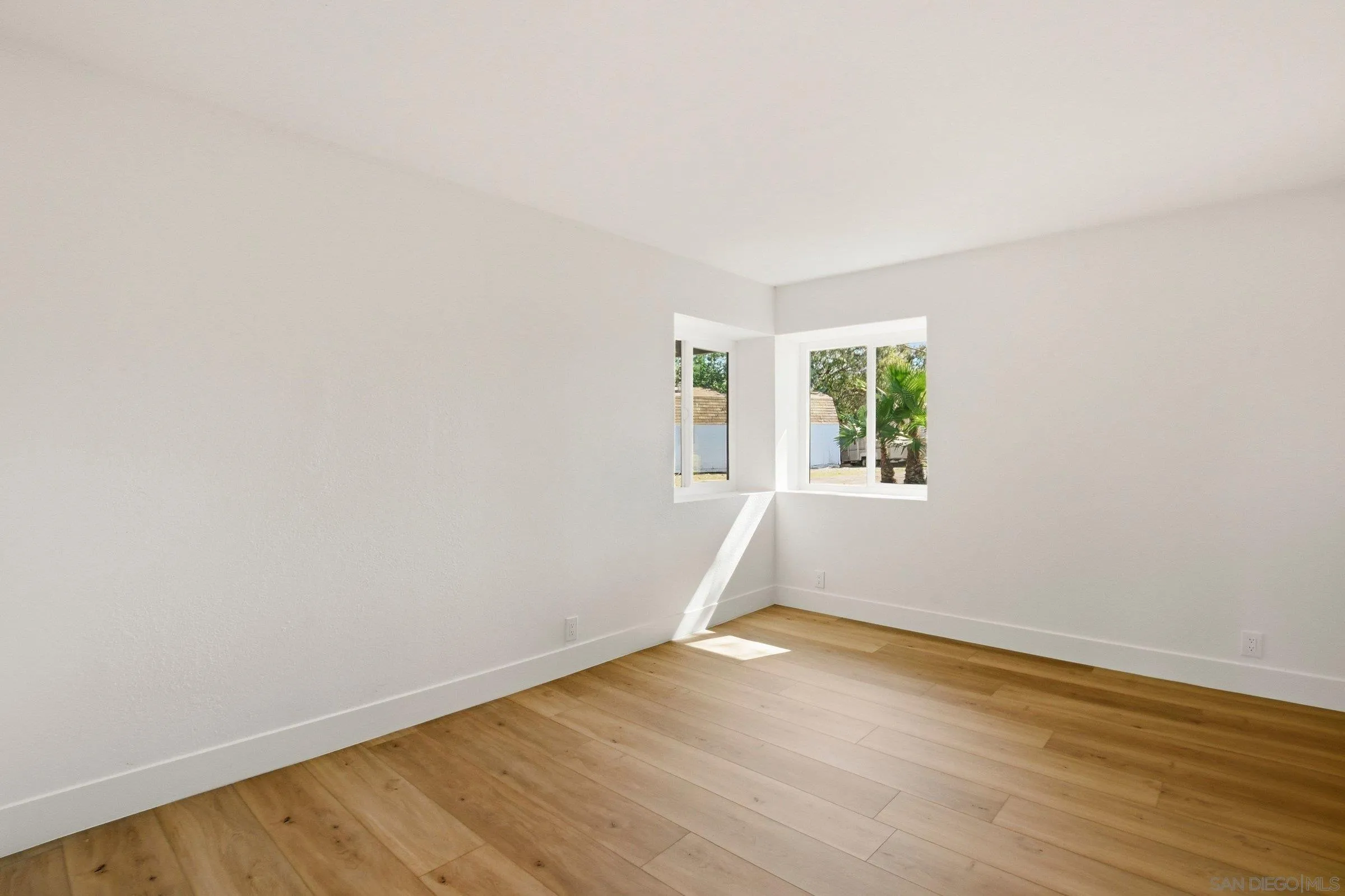 646 Barsby Street Vista, CA 92084 - Photo 26 of 48 an empty room with wooden floor and windows