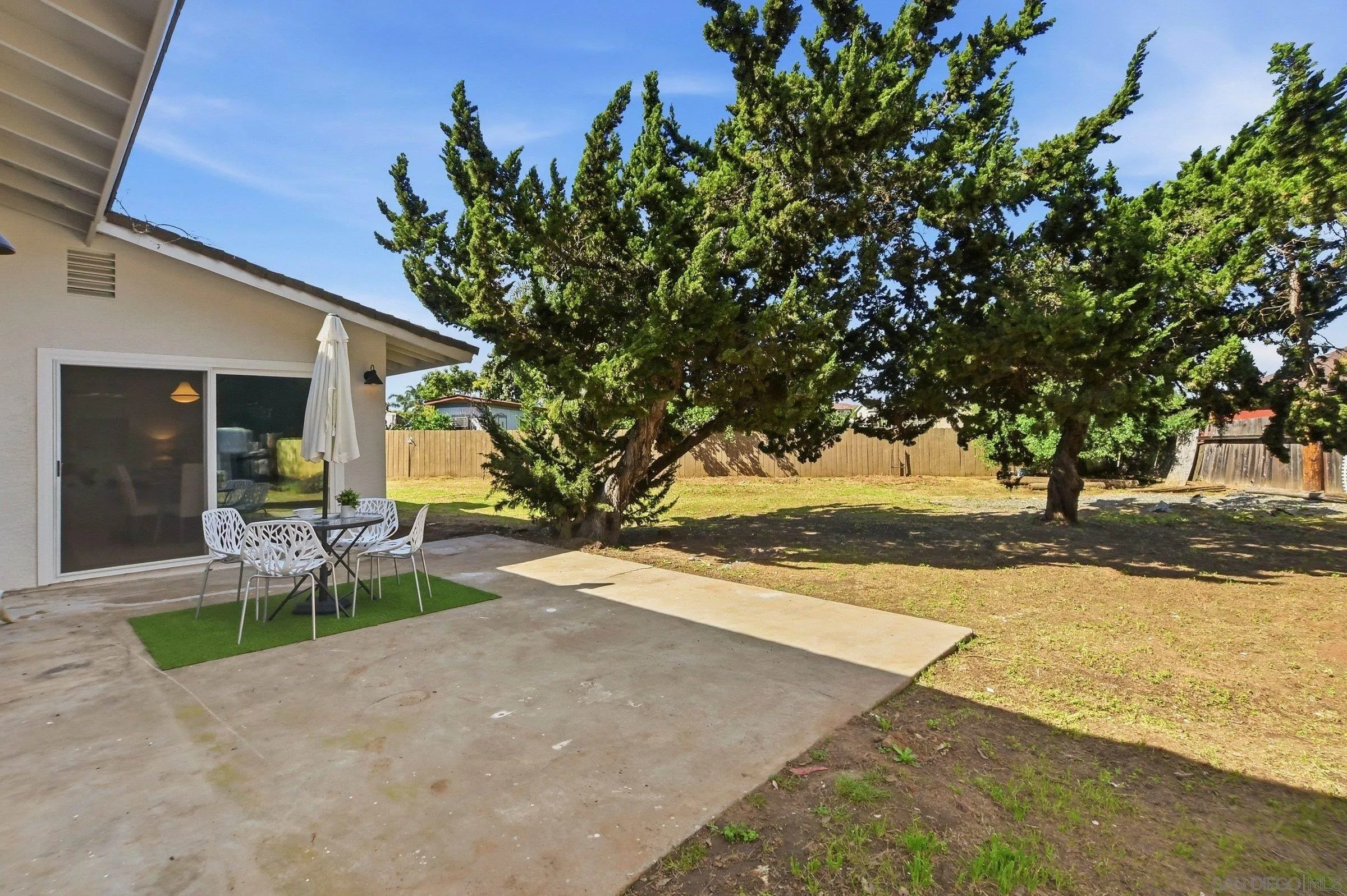646 Barsby Street Vista, CA 92084 - Photo 42 of 48 a view of a backyard with table and chairs under an umbrella