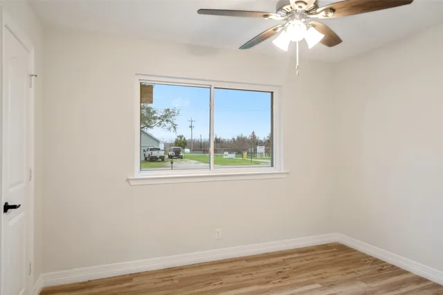an empty room with a window and wooden floor