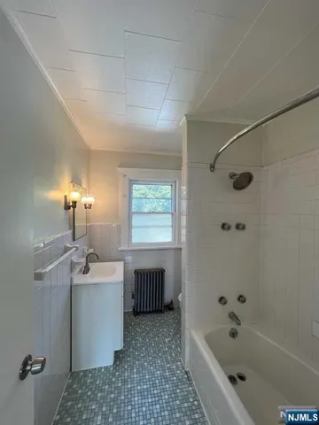 a bathroom with a tub sink and mirror