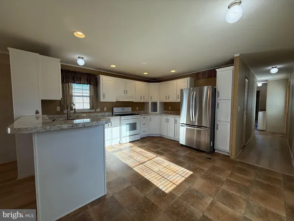 a kitchen with stainless steel appliances granite countertop a refrigerator a stove a sink and a microwave