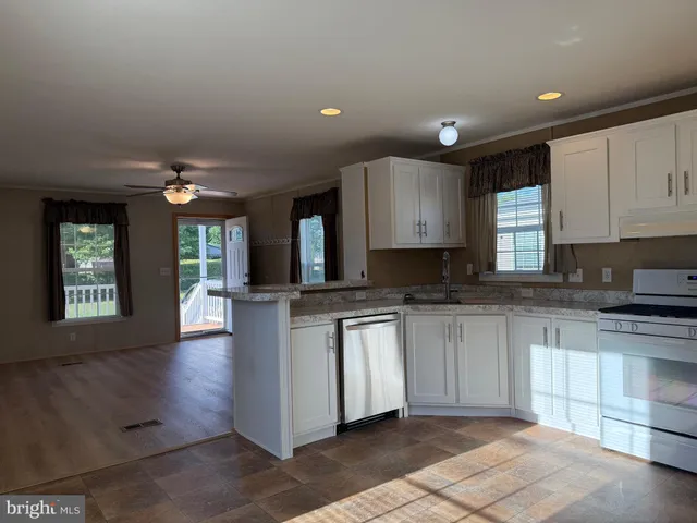 a kitchen with granite countertop a sink window and cabinets
