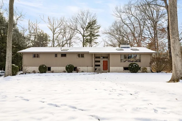 a front view of a house with a yard covered with snow in front of house