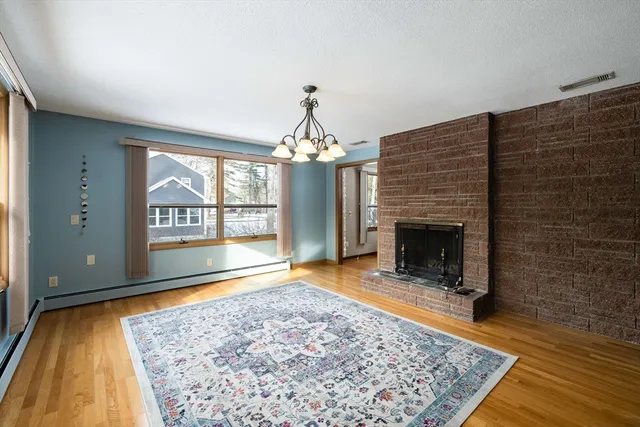 wooden floor fireplace and windows in an empty room