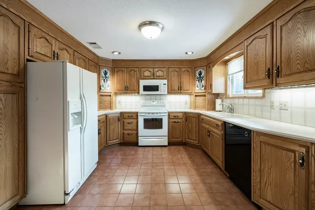 a kitchen with stainless steel appliances granite countertop a refrigerator and a stove top oven