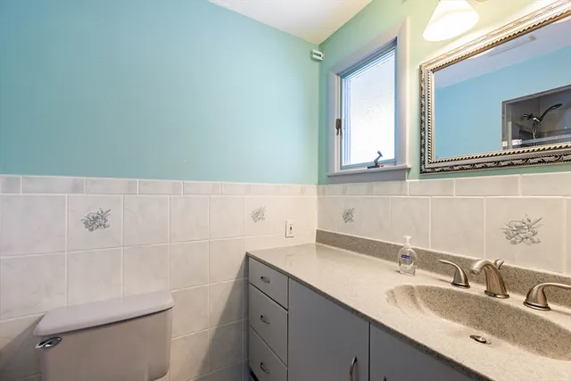 a bathroom with a sink a toilet and mirror