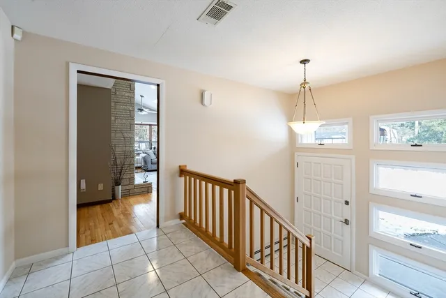 a view of a hallway view with wooden floor and chandelier