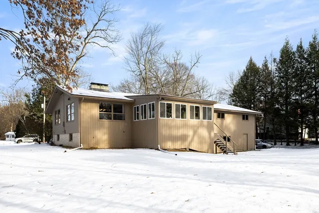 a front view of a house with a yard covered with snow in front of house