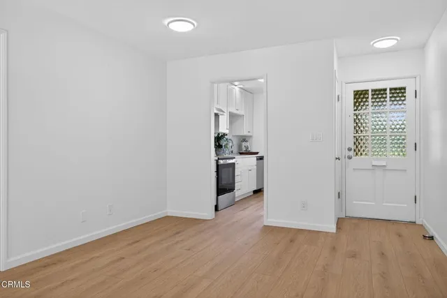 wooden floor in an empty room with a kitchen