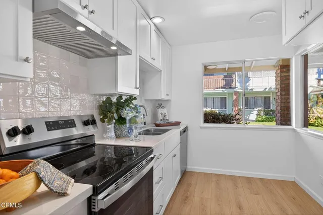 a kitchen with stainless steel appliances kitchen island granite countertop a lot of counter space and a window
