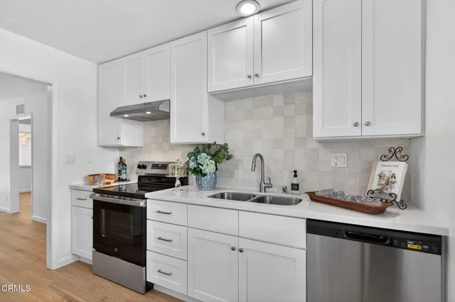 a kitchen with white cabinets and a stove