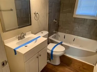 a bathroom with a sink toilet vanity and tub