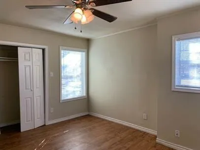 an empty room with windows and fan