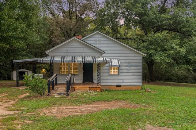 a backyard of a house with barbeque oven table and chairs