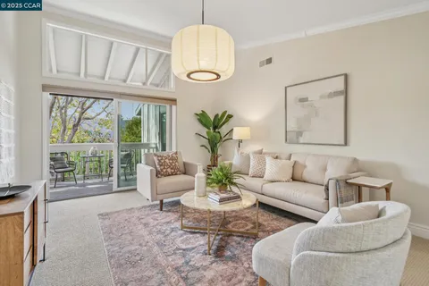 a living room with furniture a chandelier and a large window