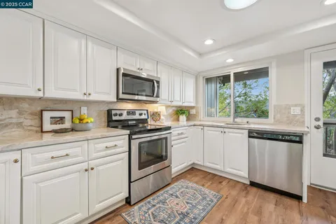 a kitchen with granite countertop appliances cabinets and a sink
