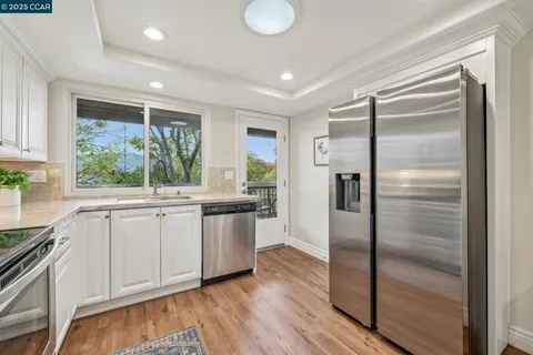 a kitchen with stainless steel appliances a refrigerator sink and cabinets
