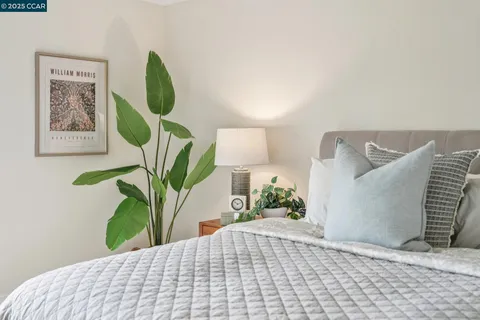 a bedroom with a bed and a painting on the wall