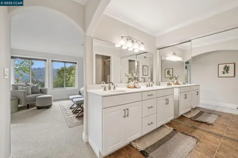 a spacious bathroom with a double vanity sink large mirror and a bathtub