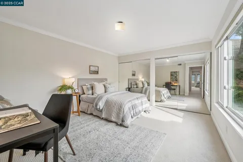 a bedroom with a bed and a large window