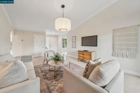 a living room with furniture chandelier and a flat screen tv