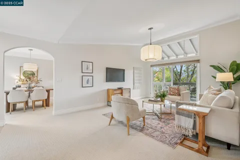 a living room with furniture a flat screen tv and a large window