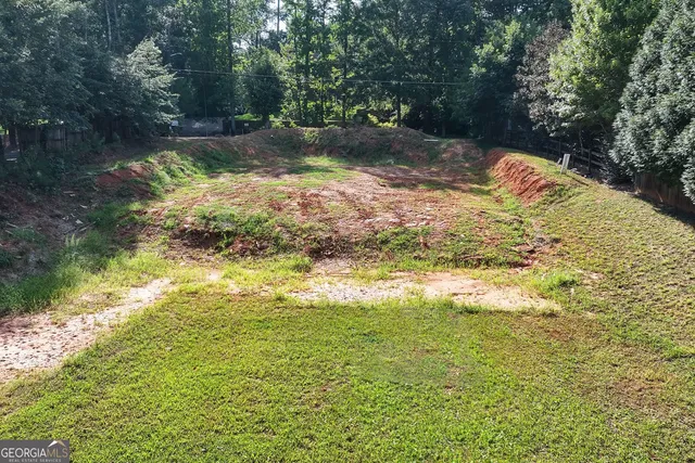 a backyard of a house with lots of green space and lake view