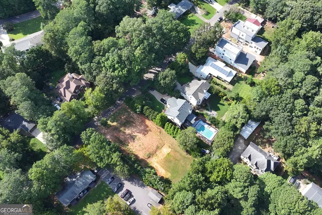 an aerial view of residential house with outdoor space and trees all around