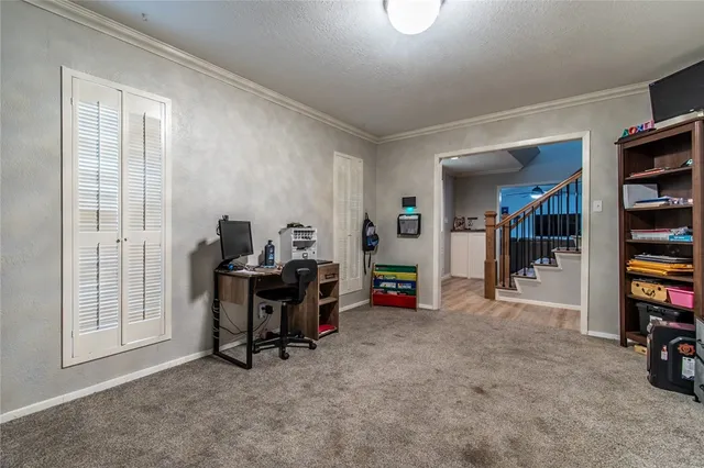 a view of a workspace with furniture and a window