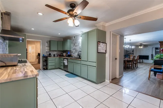 a kitchen with stainless steel appliances kitchen island granite countertop a refrigerator oven a sink a dining table and chairs with wooden floor