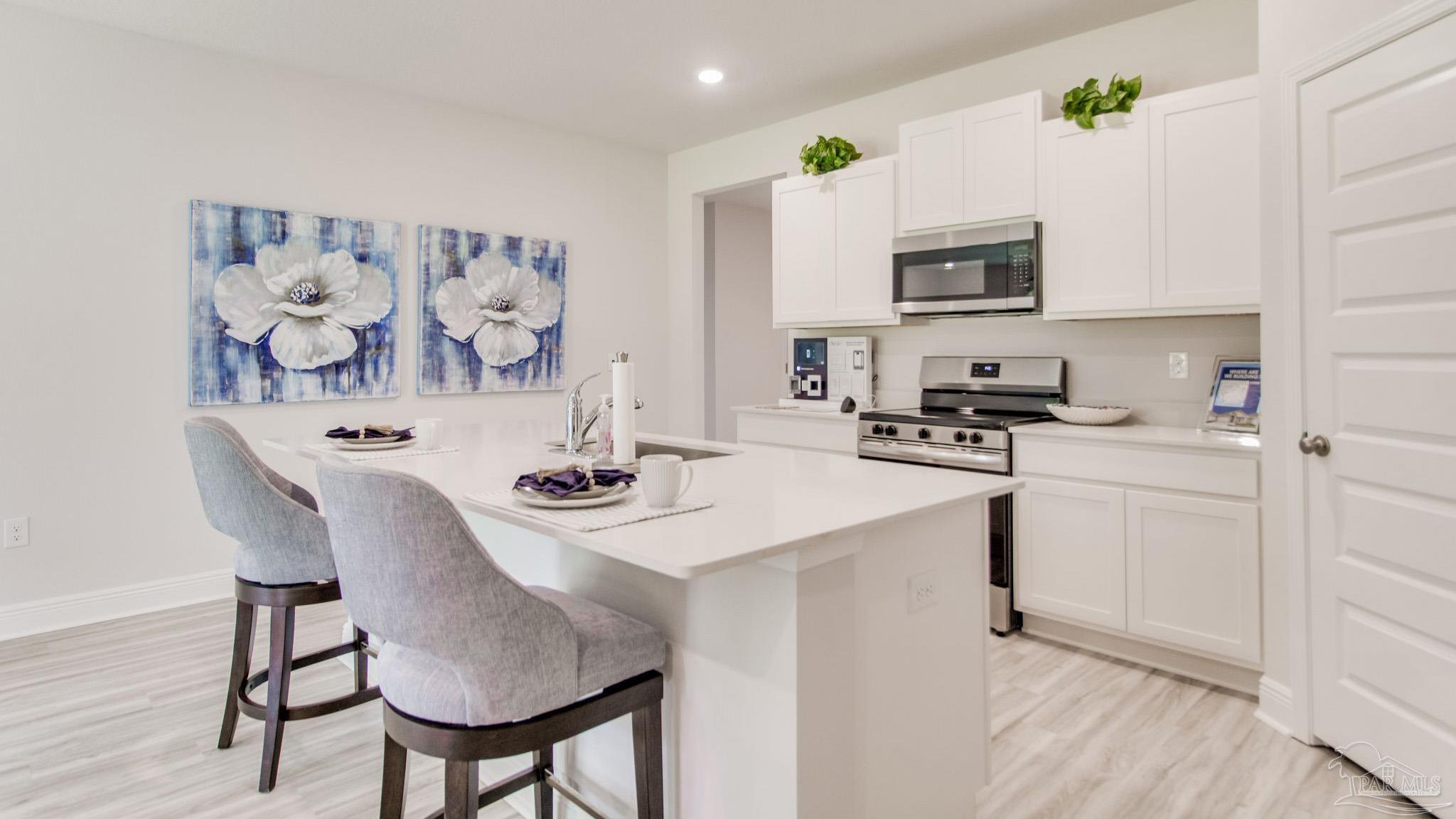 2653 Chevy Circle Pace, FL 32571 - Photo 26 of 31 a kitchen with stainless steel appliances a white table chairs and a refrigerator