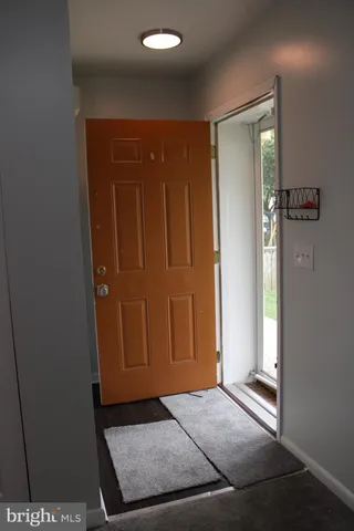 a view of a hallway with wooden floor and cabinet